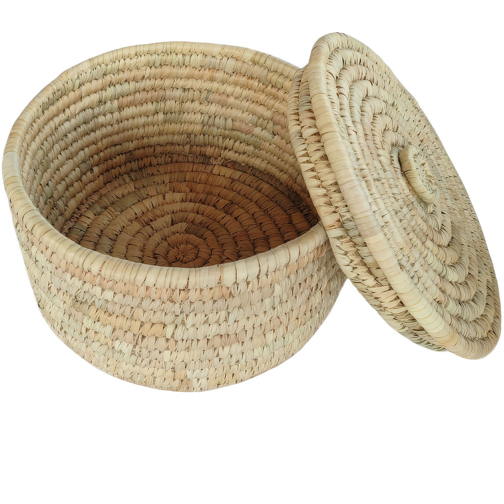 Cesto rotondo per riporre oggetti, realizzato in foglie di palma, con una capienza di 15 litri, coperchio ribaltabile e interno a vista.