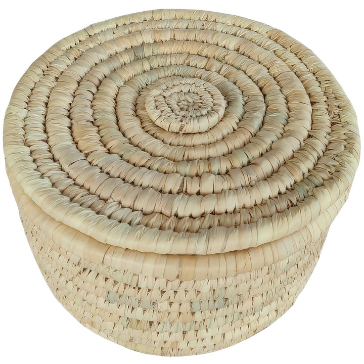 Cesto rotondo per riporre oggetti, realizzato in foglia di palma, con un diametro di 28 cm e coperchio chiuso con motivo a spirale.