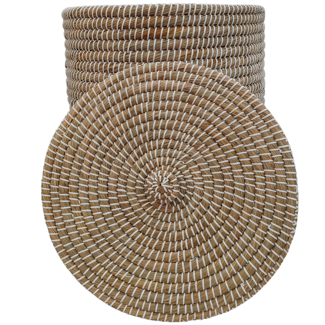 Cesto intrecciato in alghe marine, nei colori naturale/bianco, con una capienza di circa 65 litri e fondo visibile quando il coperchio è rimosso.