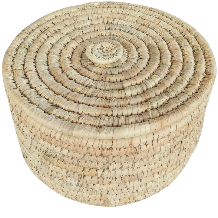 Cesto rotondo intrecciato in foglia di palma, con una capienza di 15 litri e un coperchio chiuso, caratterizzato da un motivo a spirale.