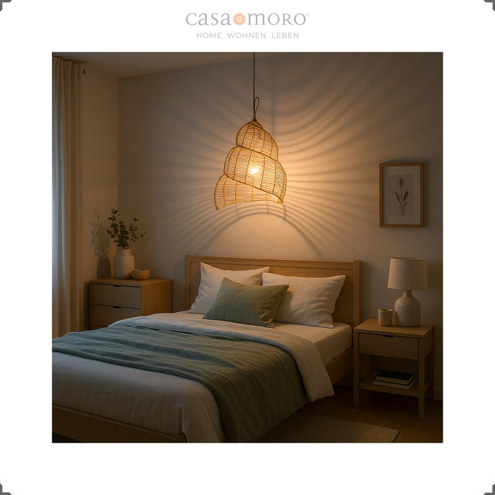 Spiralig geformte Rattan-Lampe als Deckenleuchte im Schlafzimmer, erzeugt warmes Licht und ruhige Atmosphäre