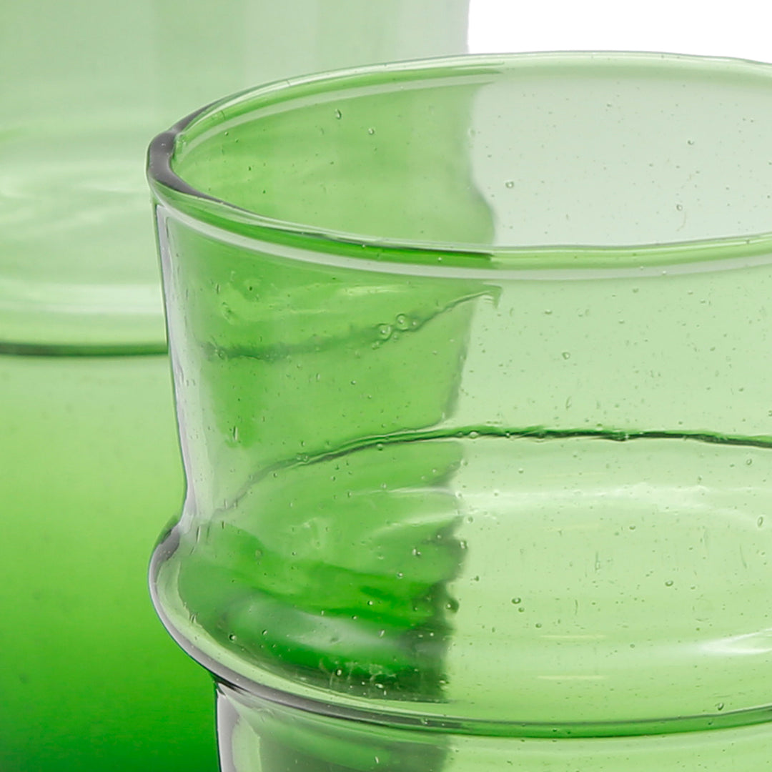 Latte macchiato servito in un bicchiere verde - struttura in vetro vivace e individuale
