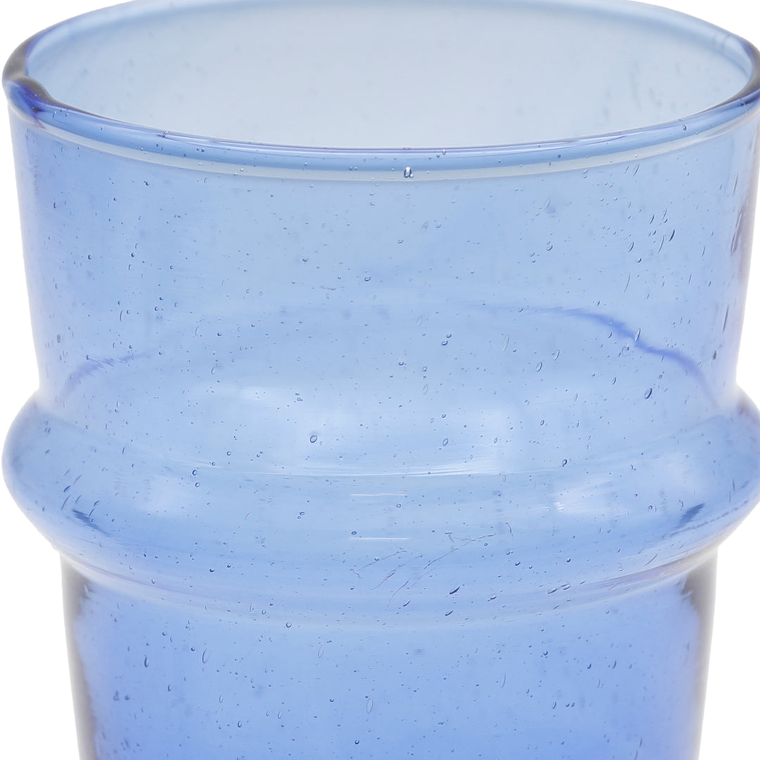 Scatto dettagliato di un bicchiere da latte macchiato: forma leggermente irregolare e inclusioni