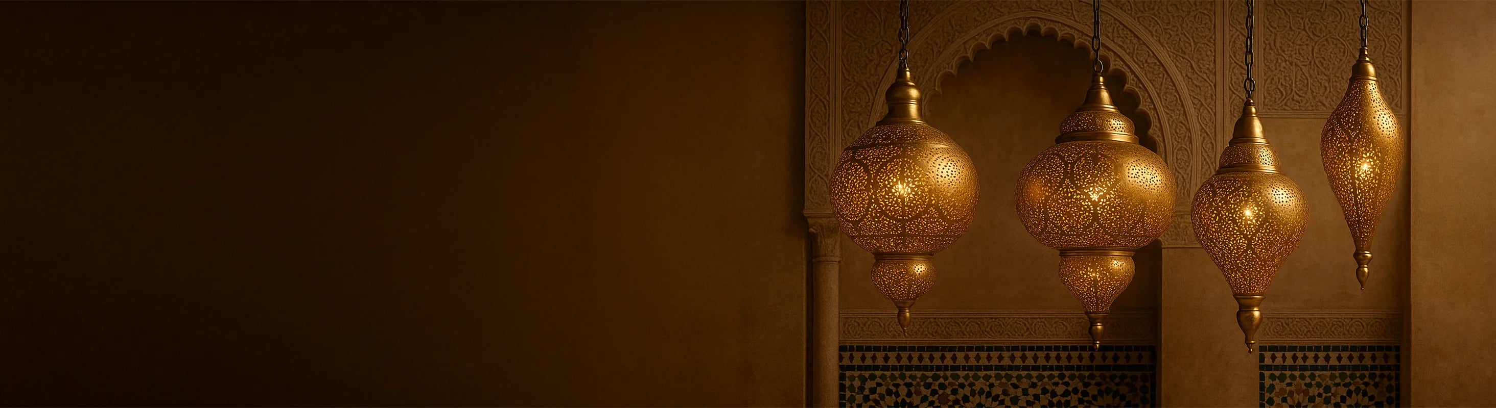 Plafoniere orientali in ottone – Lampade da soffitto orientali in ottone sono appese davanti ad archi decorati e pareti a mosaico in un interno marocchino.