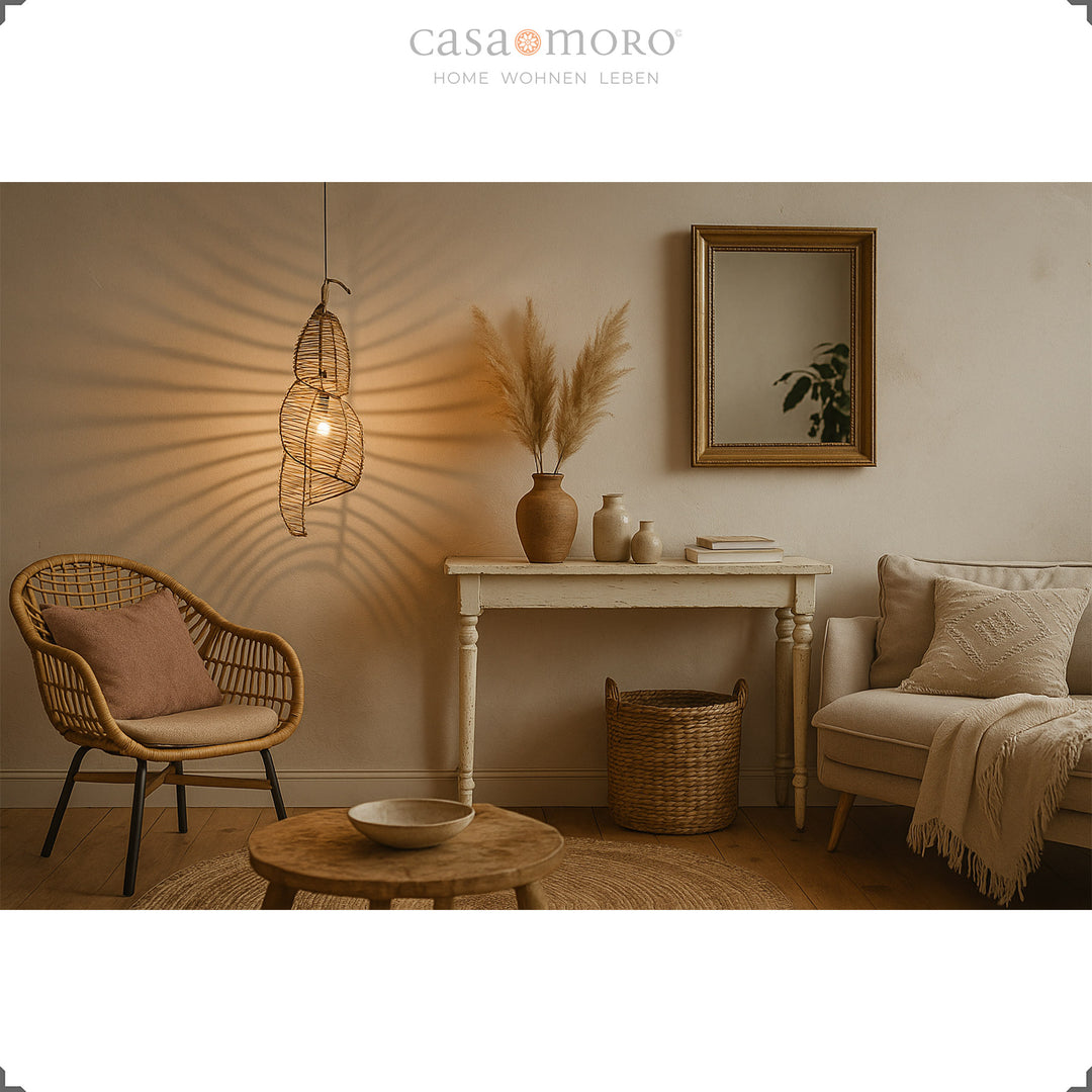 Rattan-Lampe über einem Esstisch im Boho-Wohnzimmer, erzeugt warmes Licht und stimmungsvolles Ambiente