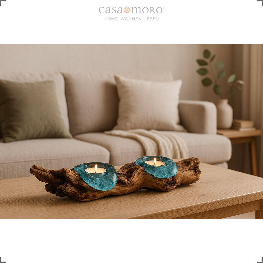 Teelichthalter aus Glas und Wurzelholz auf einem Couchtisch, sein warmes Licht ergänzt das helle, gemütliche Wohnzimmerambiente.