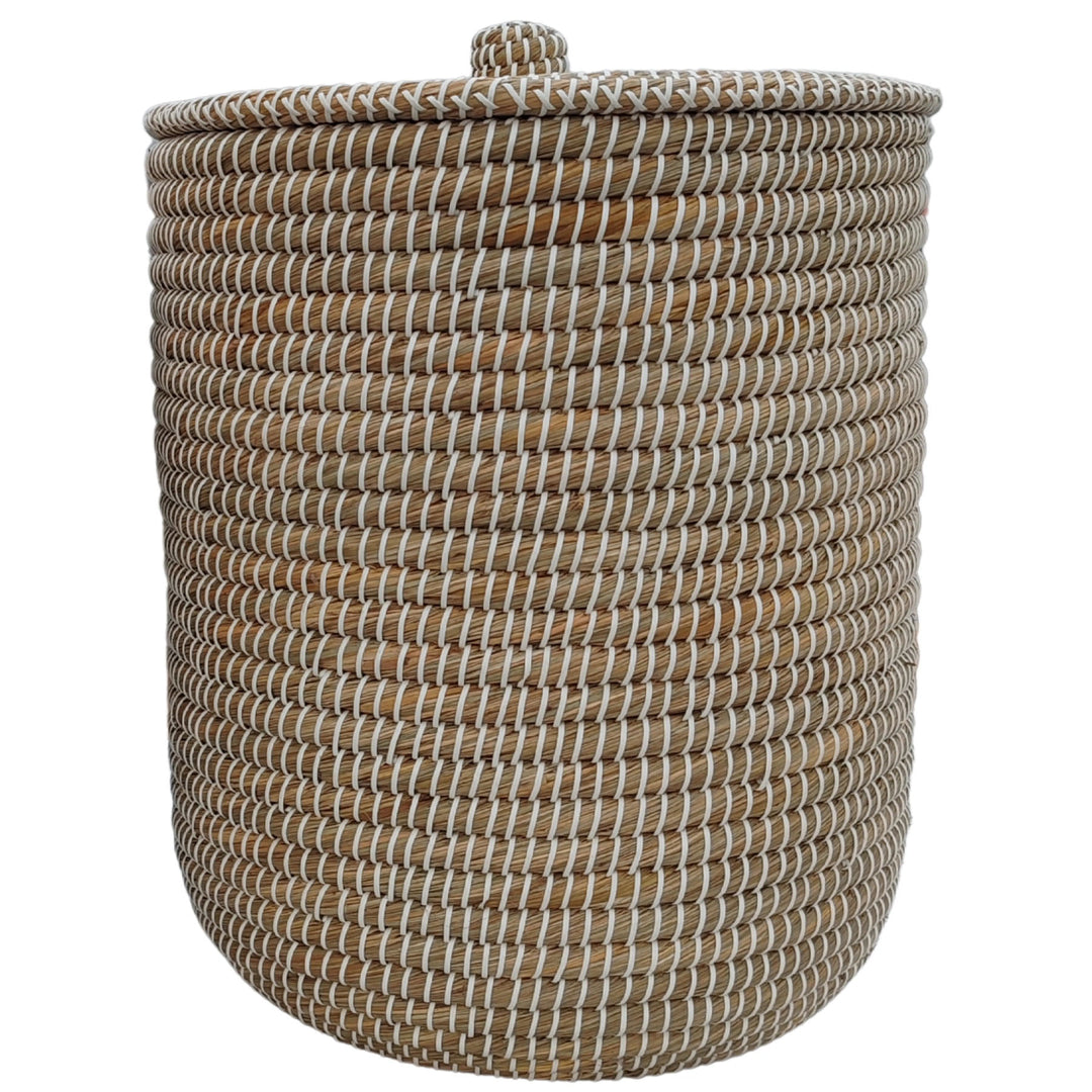 Cesto portabiancheria rotondo in alghe marine, nei colori naturale/bianco, con coperchio chiuso e una capacità di circa 65 litri.