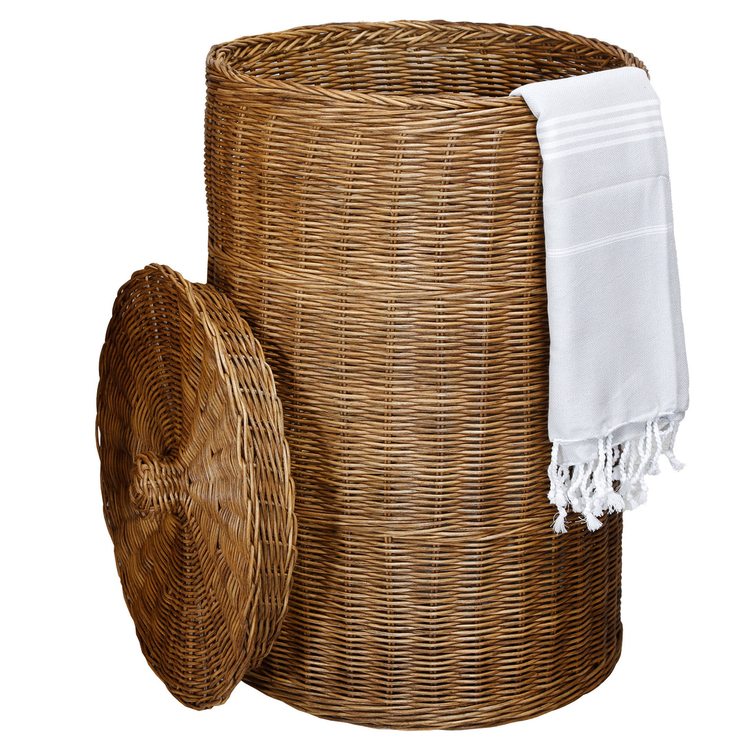 Dunkler, runder Wäschesammler mit Deckel aus geflochtenem Rattan, dekoriert mit weißem Hamamtuch